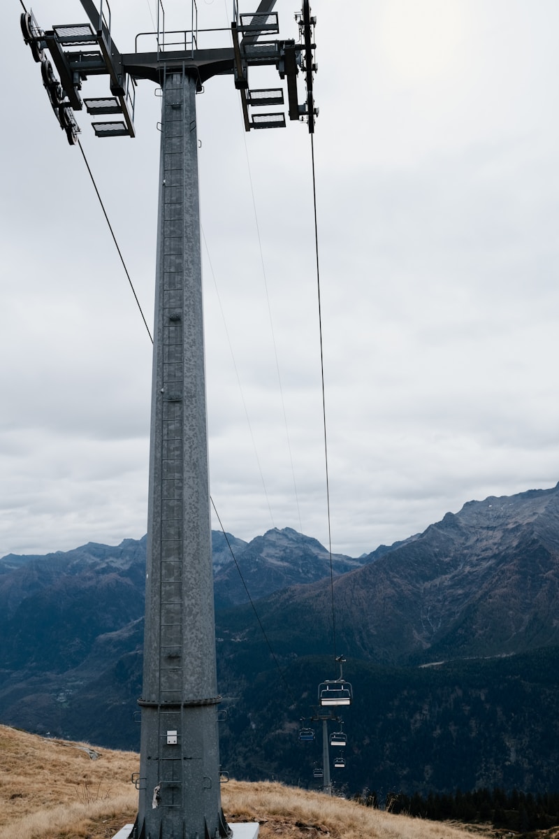 A ski lift going up a hill with mountains in the background
